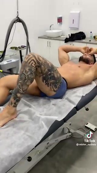 Str8 tattooed Arab man stretching after massage image