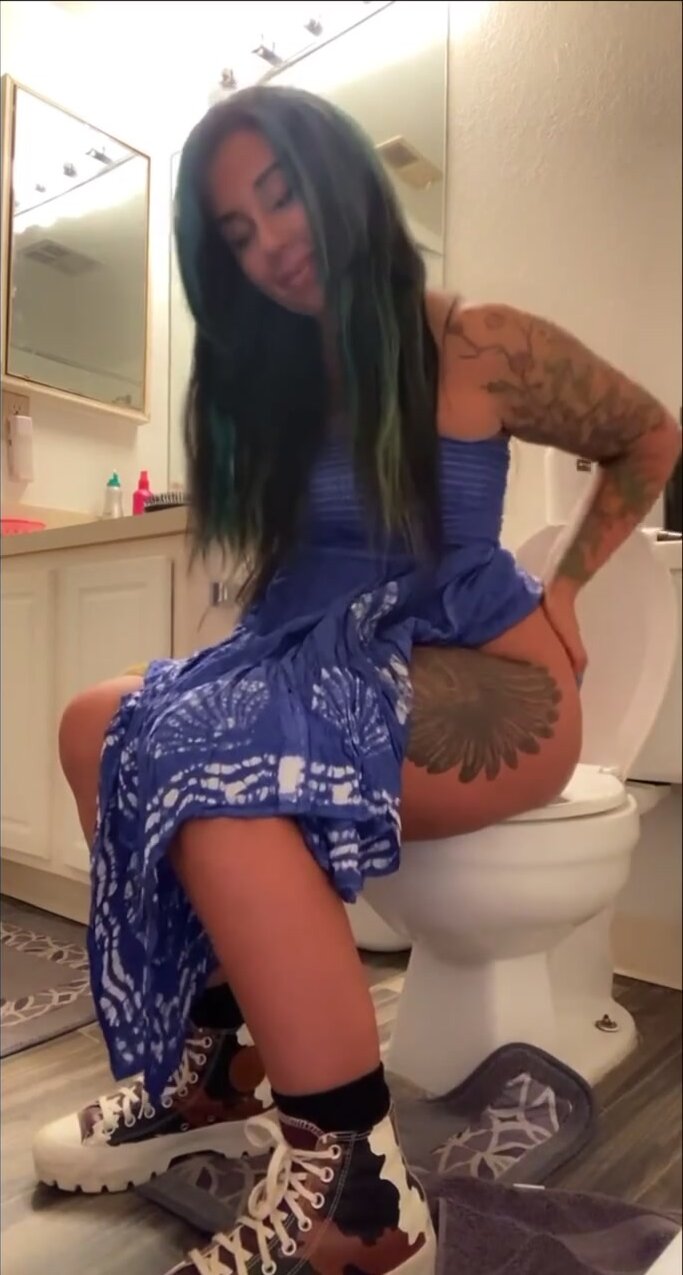 Tatted girl sitting on toilet