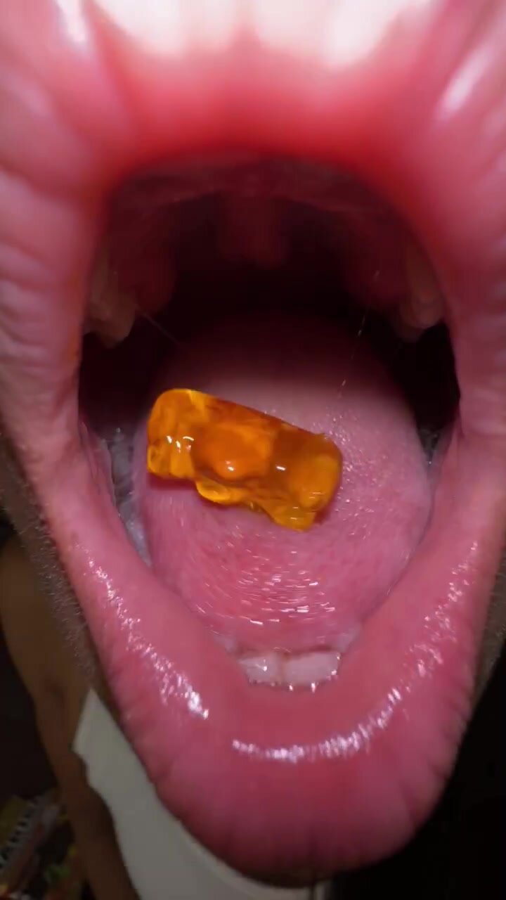 Asian girl chews and swallows gummy bear