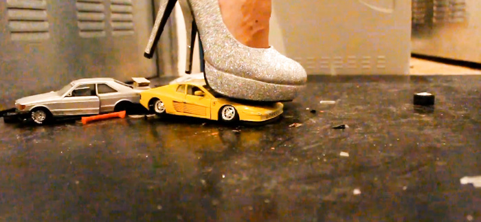 Sexy girl crush toy car in high heels