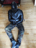 Muzzled slvae in a leather straitjacket