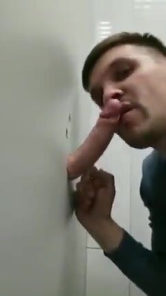 Sucking on a massive uncut cock at the public gloryhole