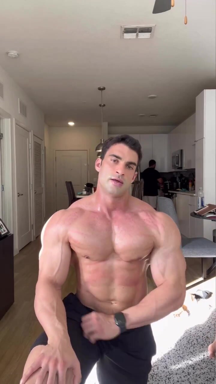 Sexy beefy bodybuilder flexes his ripped muscles