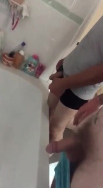 Two drunk friend peeing in the bathtub