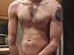 Scruffy dude jerking off in the kitchen