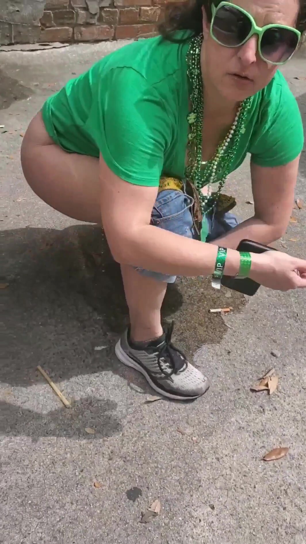 Woman pisses between cars at St. Patrick's Day Parade