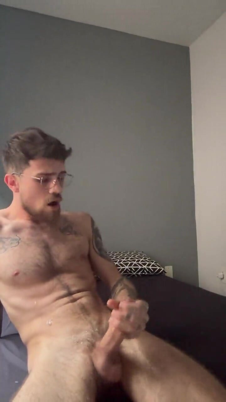 Bearded guy in glasses covers his hairy body in cum