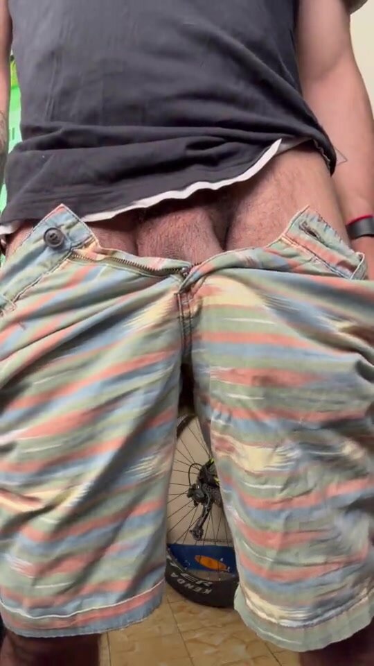 Pulling down his shorts to expose big brown uncut cock