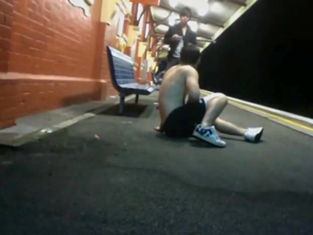 Young guy strokes on public train platform