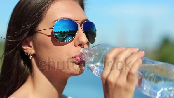 girl taking water on the beach