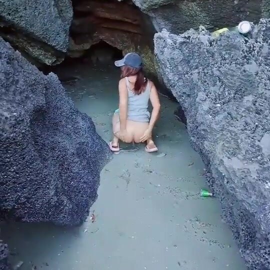 Thai woman pops a squat in a cave