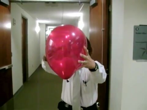 An Officer squeezes popping a big balloon