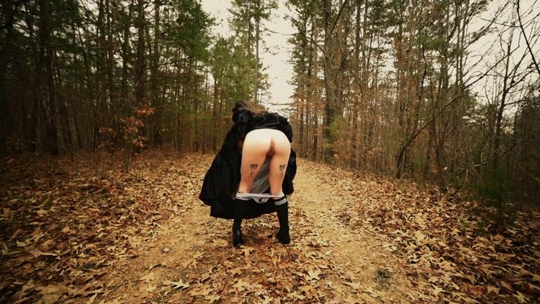 Girl in dress pee in the woods