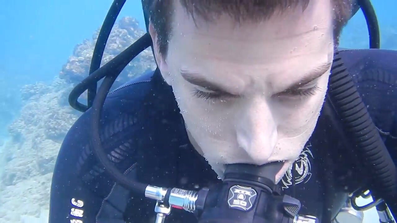 Scubadiver removing mask underwater in sea