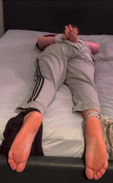 Teen boy tied up on bed