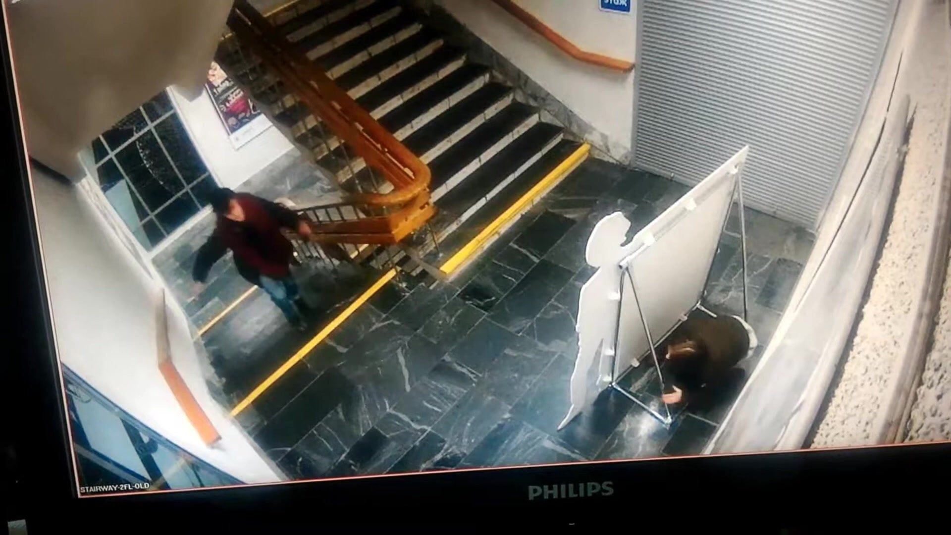 Girl pees behind sign on stairway