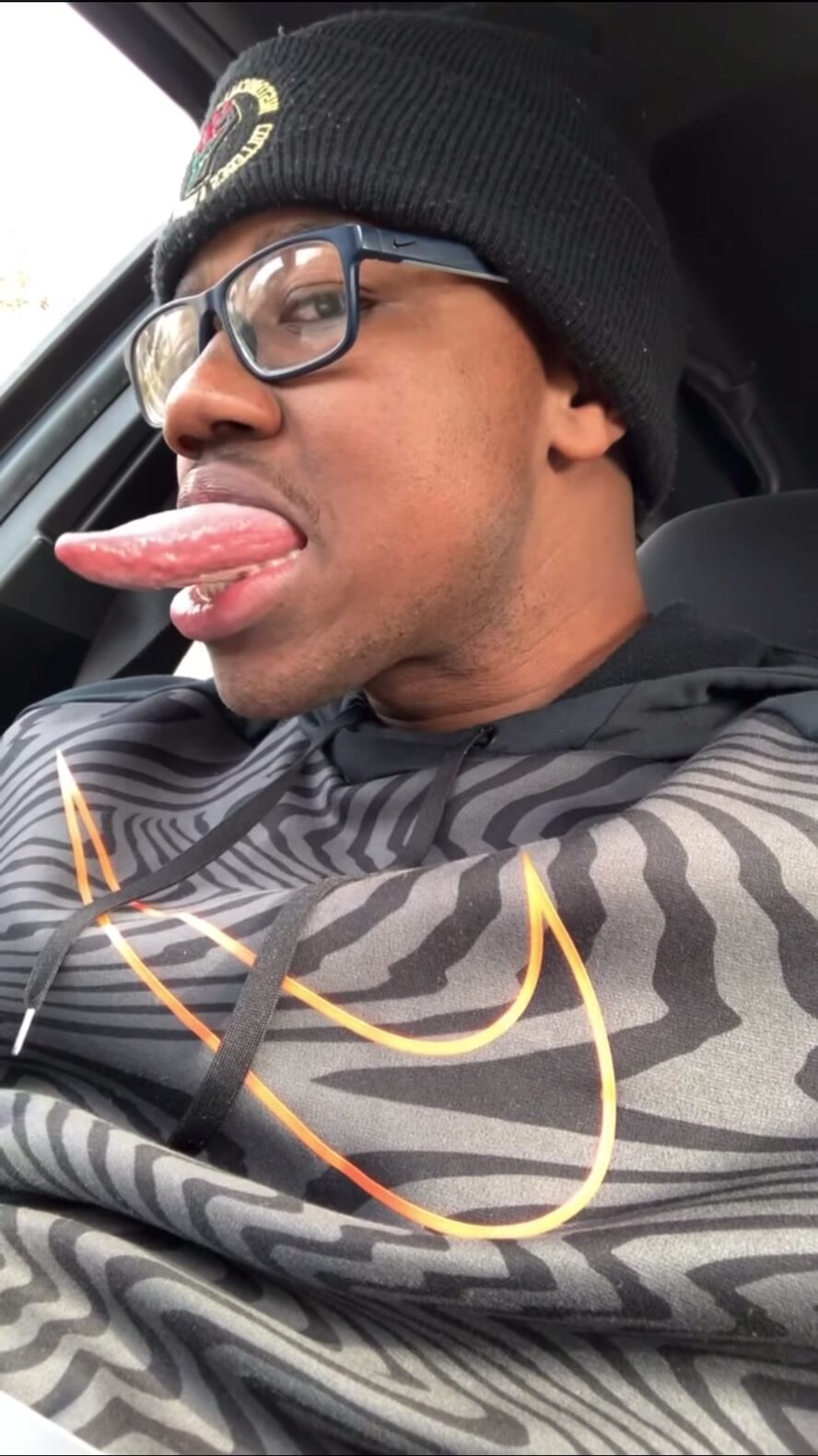Black man sticks long pink tongue out