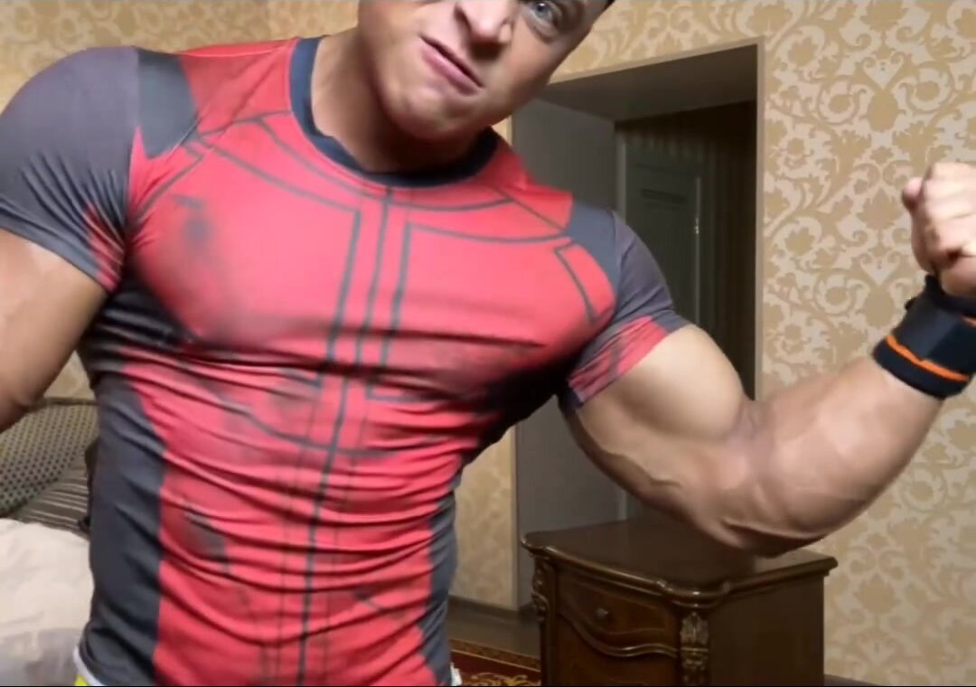 tanned hunk flexes muscles/ lifts furniture