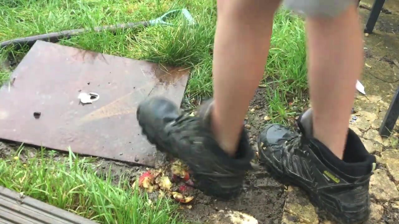 Man stomping hard on apples with big work boots