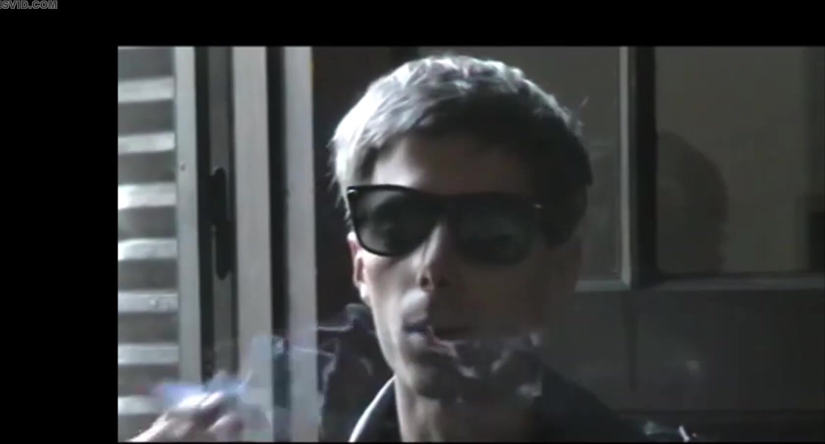 young guy smokes with sunglasses