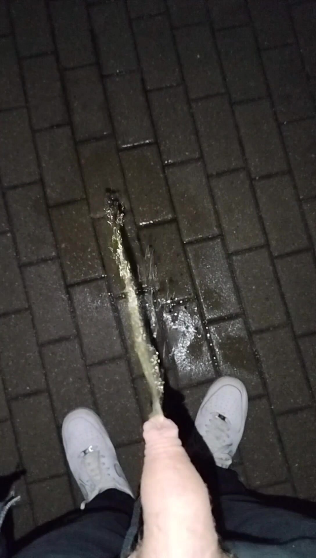 Flaccid penis pissing on the sidewalk at night