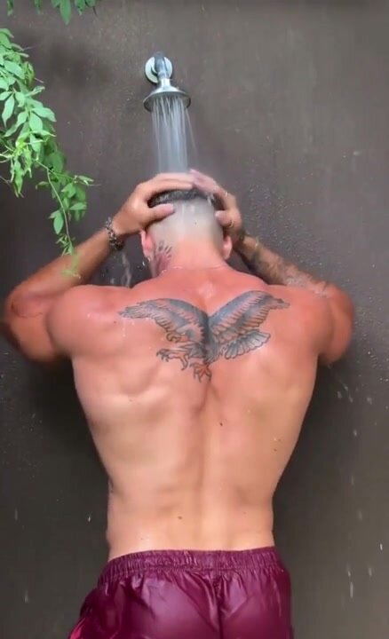 Muscled dude showering