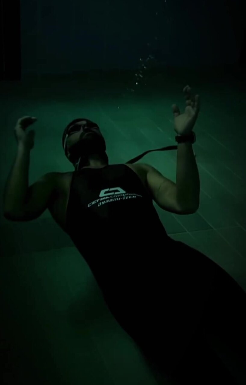 Blowing bubbles underwater in tight wetsuit