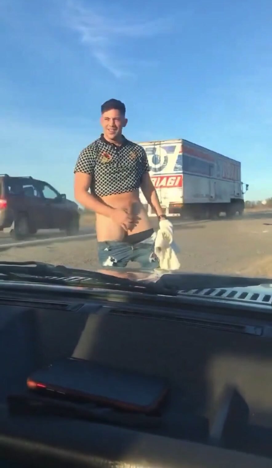 Muscular dude is flashing his dick by the highway