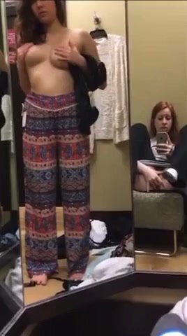 Redhead masturbates while friend tries on clothes