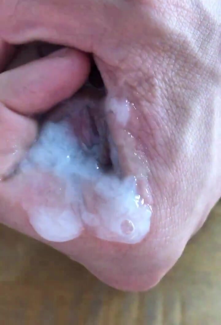 Uncut cock head emerges from pool of hot cum and precum