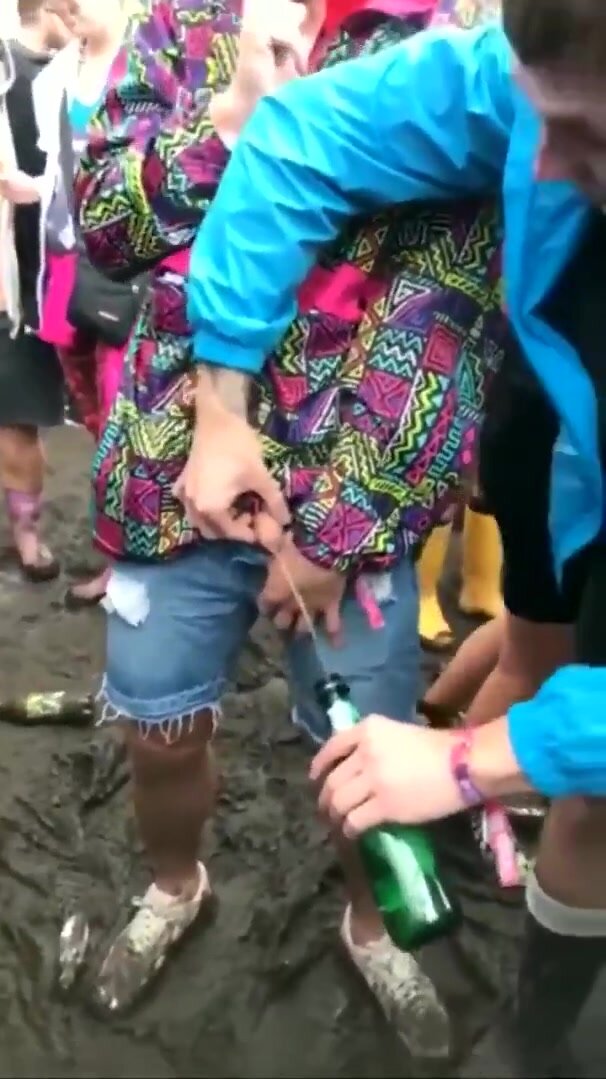 Helping his friend piss in a bottle at the festival