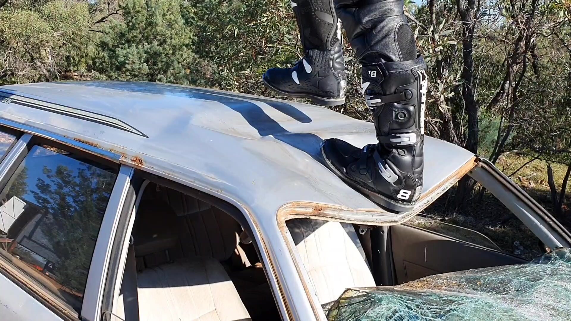 The Shiny Helmeted Stomper stomps on roof of old car