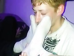 Guy sniffs two friends socks