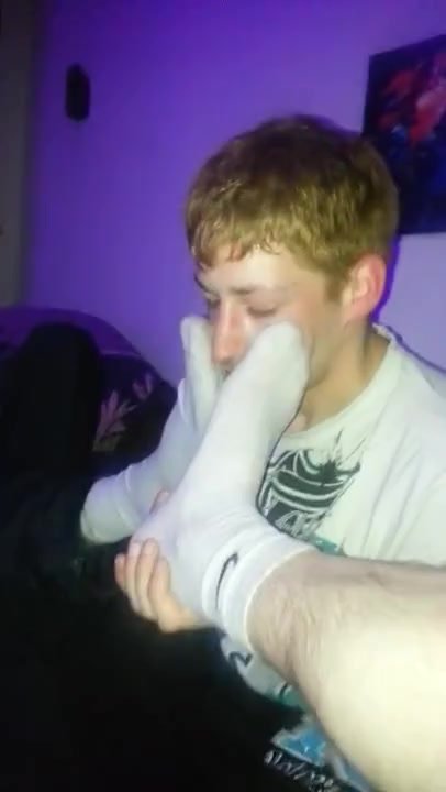 Guy sniffs two friends socks