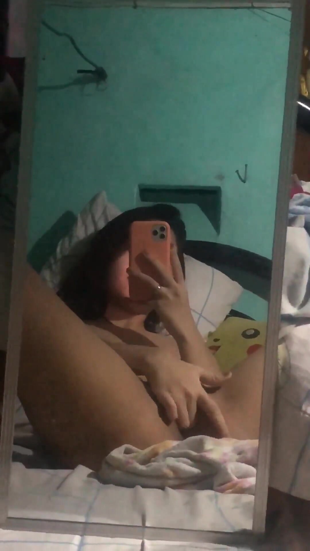 Cute young Asian touches herself in mirror in bedroom