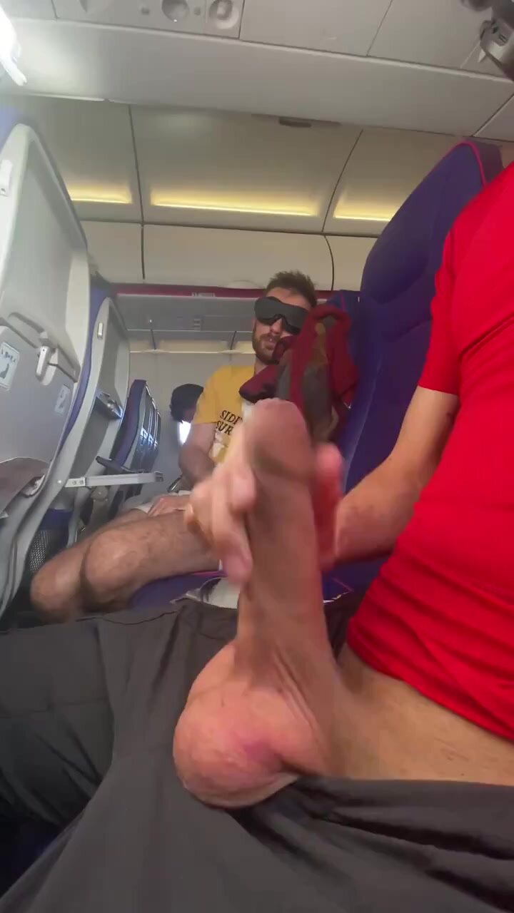 Horny guy wanks his uncut cock on plane during flight