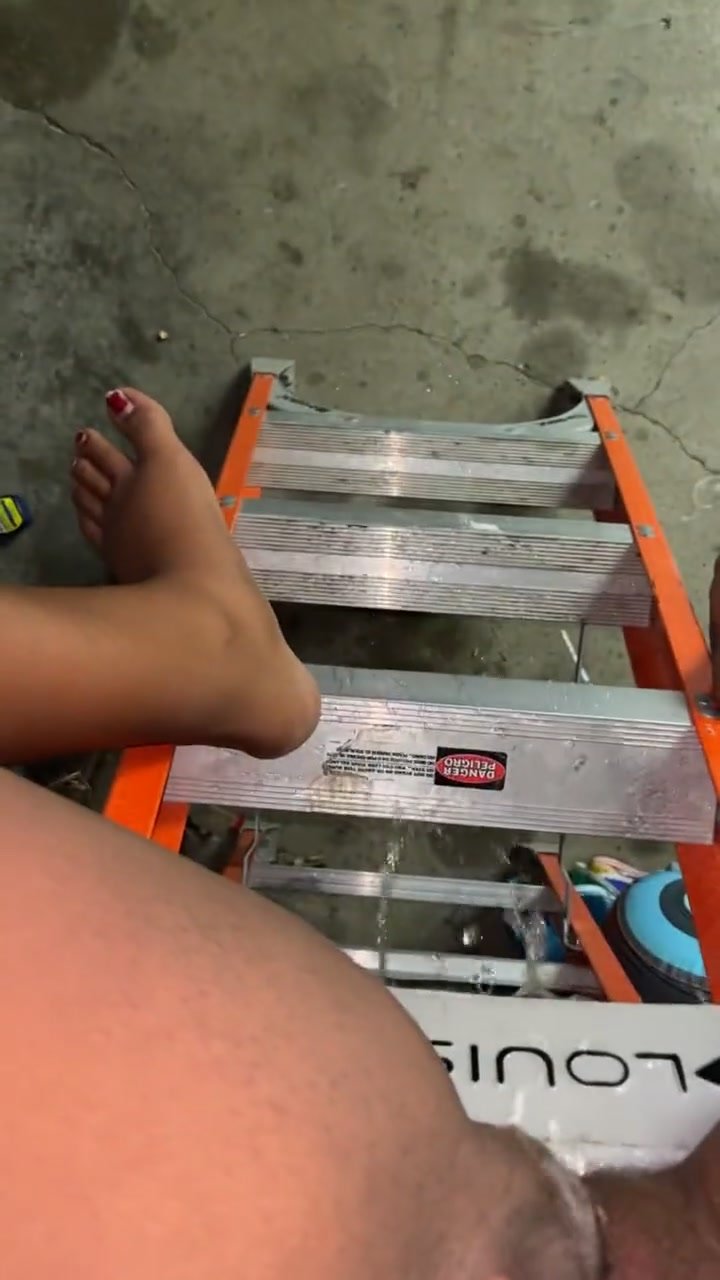 Ebony pees down the ladder in the garage