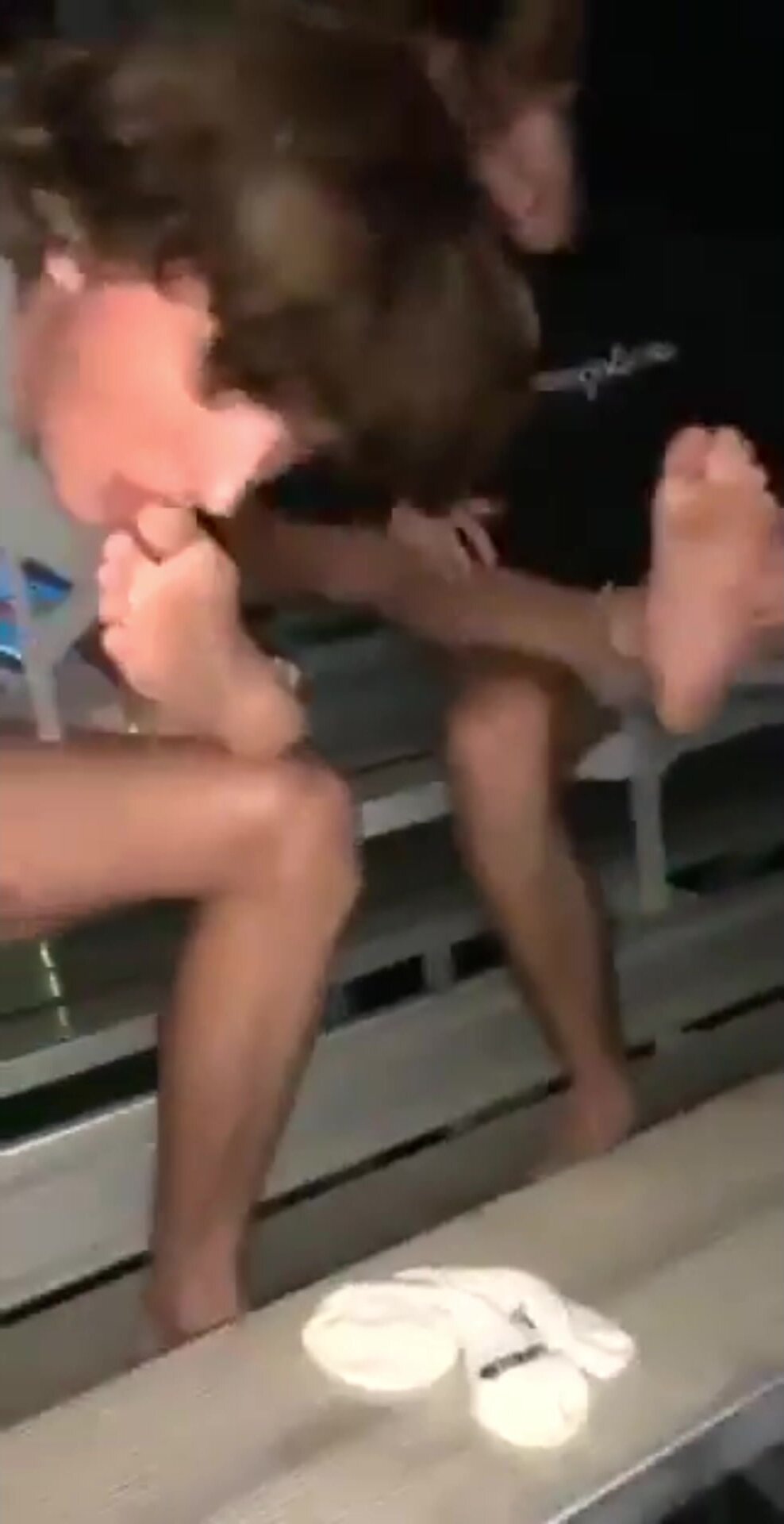 two white boys play with their homie’s feet