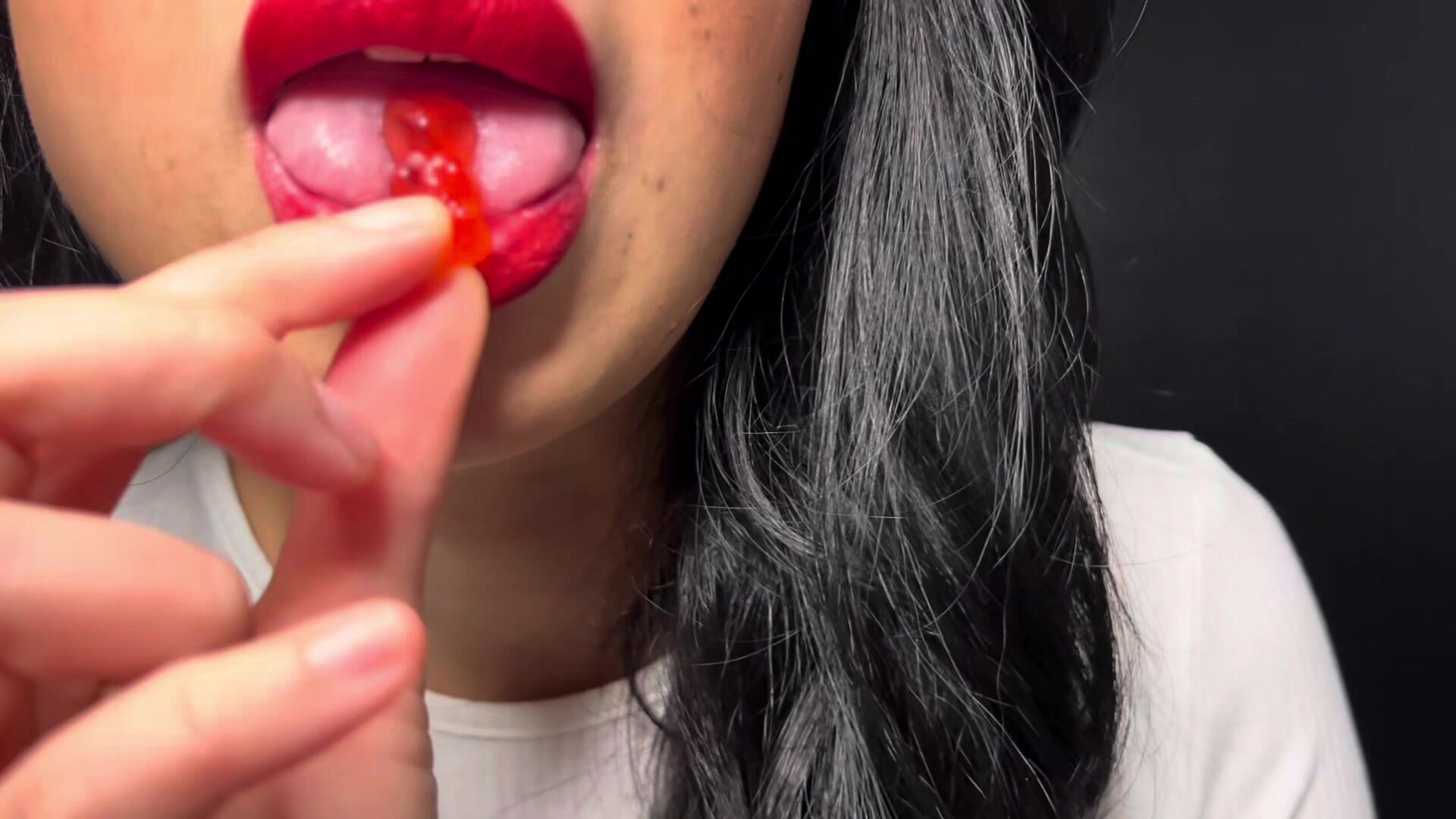 Asian girl big lips chew, mouthplay gummy bears
