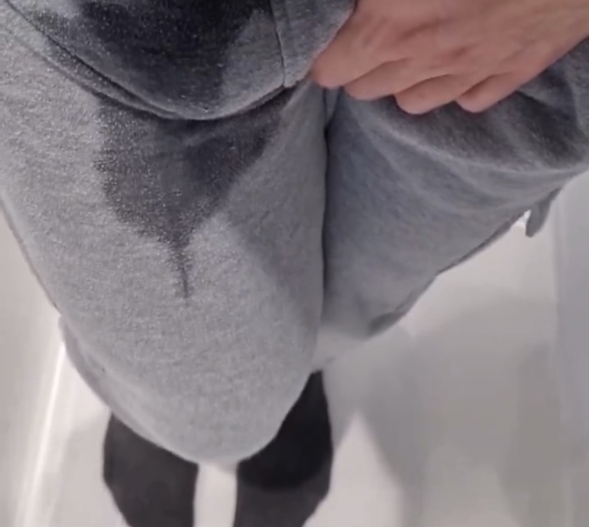 Guy wetting himself in sweatpants