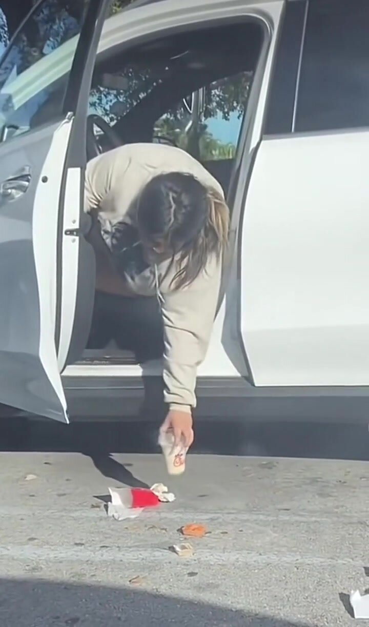 Trashy girl littering in a parking lot