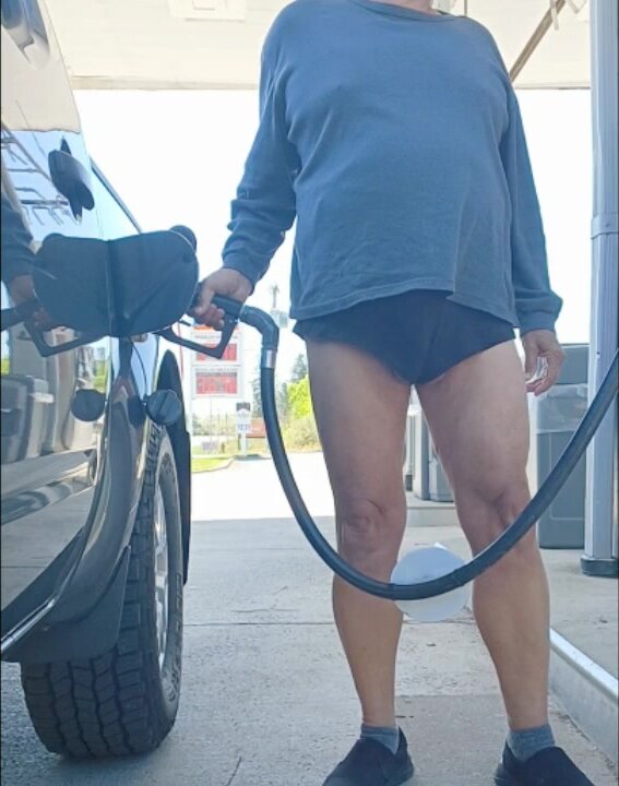 Old man with short skirt gets gas