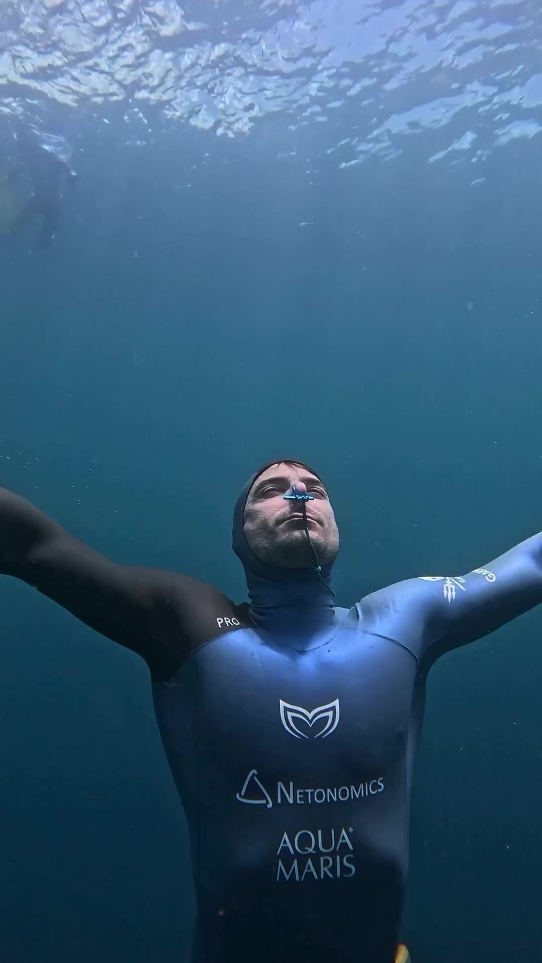 Barefaced underwater freediver surfacing