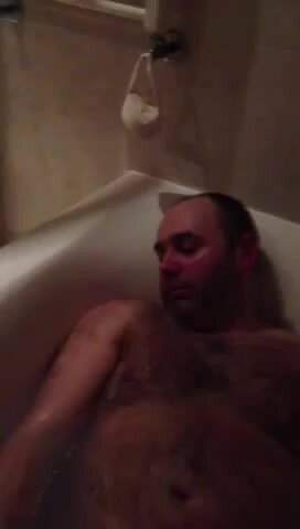 Guy sleeping in bathtub