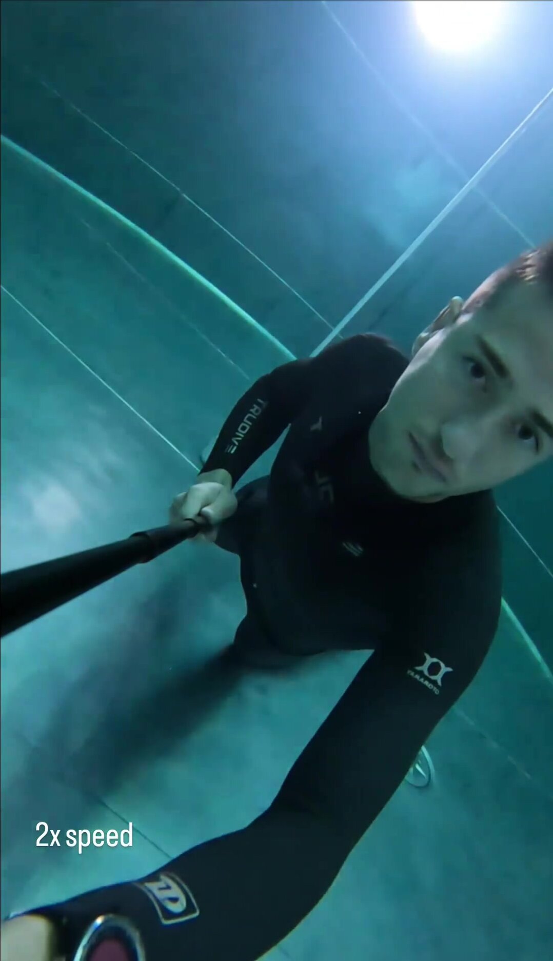 Deep dive underwater, barefaced wearing tight wetsuit