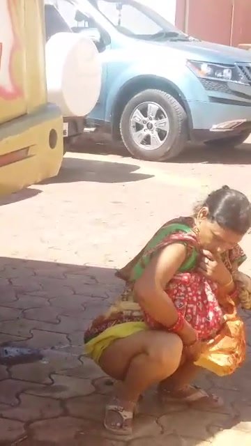 Indian Ladies peeing behind bus