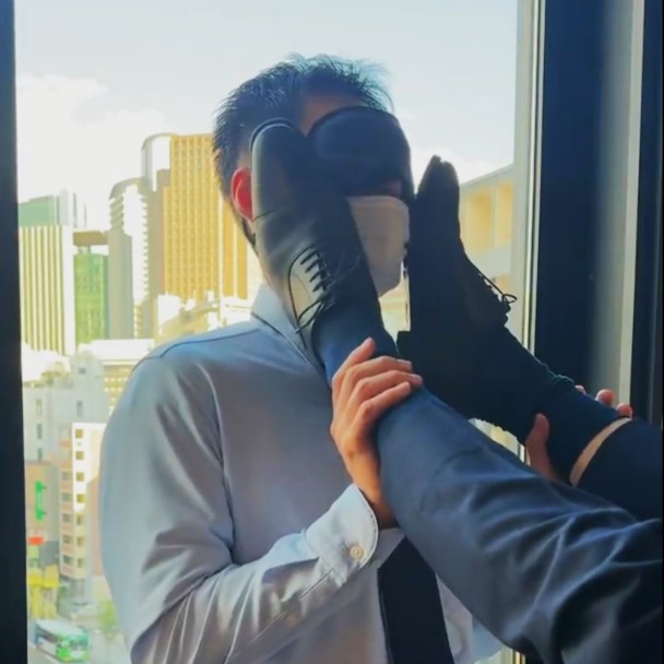 Slave man with shoes and socks shoved in his face.