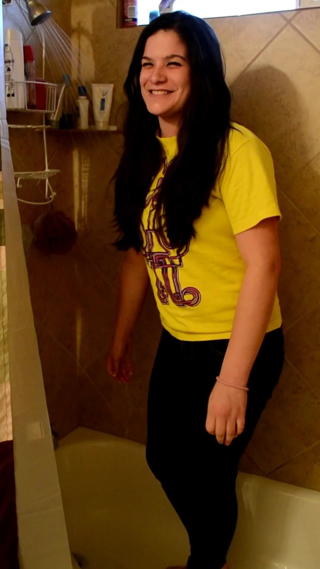 candid girl in dark jeans and yellow shirt showering