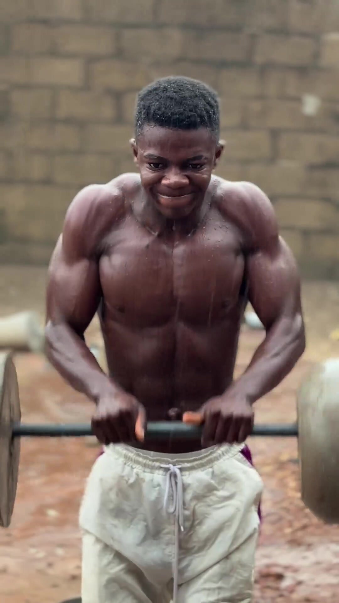 Young black african muscle training under the rain