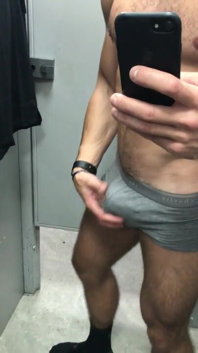 Muscle jock plays with bulge in changing room